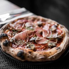 A pizza with prosciutto