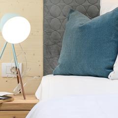 Primo piano del letto matrimoniale con comodino e lampada