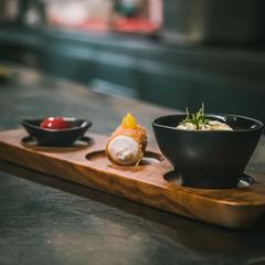Elegantes Dessert-Trio auf Holzbrett mit Creme, Cannolo und Fruchtkompott