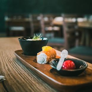 Elegant dessert trio on a wooden tray with cream, cannolo and fruit compote