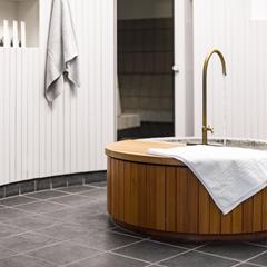 Vasca in legno con acqua corrente e asciugamani bianchi nella nostra spa