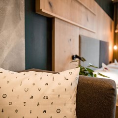 Im Vordergrund ein Sofa, im Hintergrund das Doppelbett