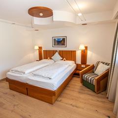 A bedroom with a double bed and an armchair
