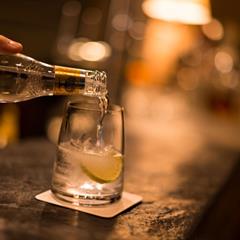 Acqua tonica viene versata su ghiaccio e lime in un bicchiere